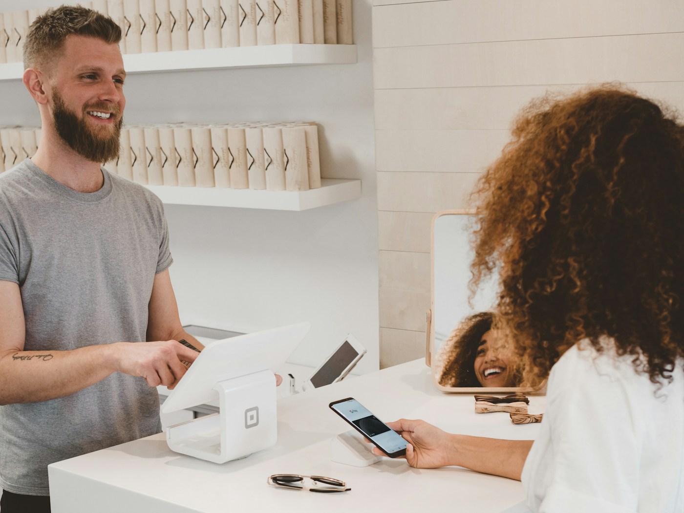Cliente che completa un acquisto online da smartphone in negozio